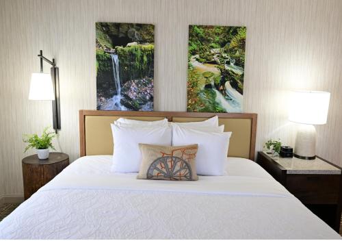 a bedroom with a white bed with two lamps at Spring Mill Inn in Mitchell