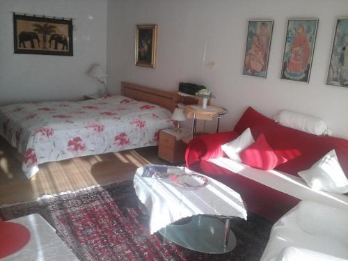 ein Schlafzimmer mit einem Bett und einem roten Sofa in der Unterkunft Appartement Haus Hamburg in Bad Füssing