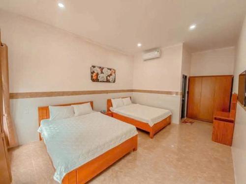 a bedroom with two beds in a room at Đạt Ngọc Hotel Mũi Né in Ấp Thiện Long