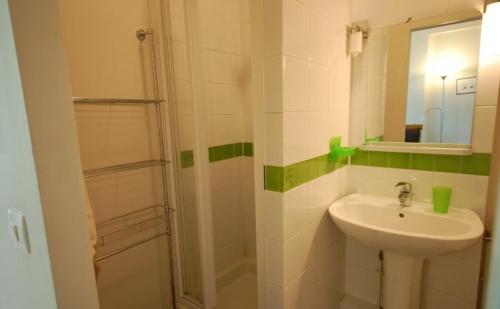 une salle de bain avec un lavabo et une douche dans l'établissement Studio face Unesco et Invalides, à Paris