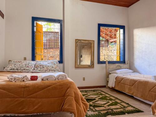 a bedroom with two beds and stained glass windows at Jardim da Música Tiradentes in Tiradentes