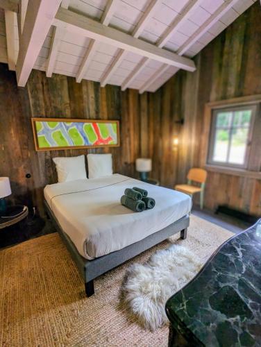 une chambre avec un lit dans une pièce aux murs en bois dans l'établissement 4 Cabanes de luxe privatisées à 300m de la Dune, à La Teste-de-Buch