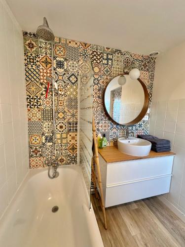 une salle de bain avec une baignoire, un lavabo et un miroir dans l'établissement Petite maison de vacances - Terrasse - Berck-Plage, à Berck-sur-Mer
