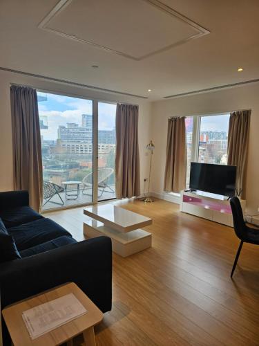 a living room with a couch and a large window at Santina Apartments in Croydon