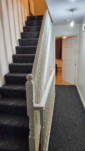 a staircase in a home with blue and white stairs at Mekees Luxury Apartment Toronto Wing in Tipton