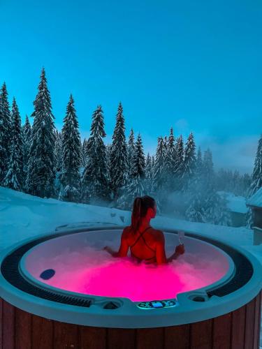 a woman sitting in a hot tub in the snow at Chata MartinSki Martinske hole in Martinske Hole