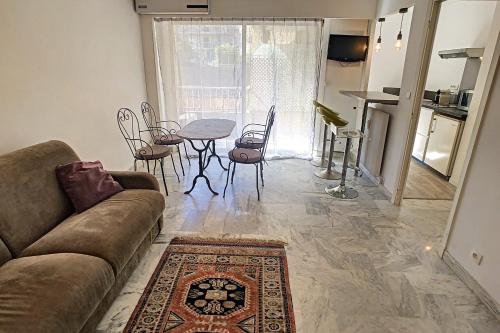 un salon avec un canapé, une table et des chaises dans l'établissement Le Majestic - Hypercentre - Croisette - AC, à Cannes