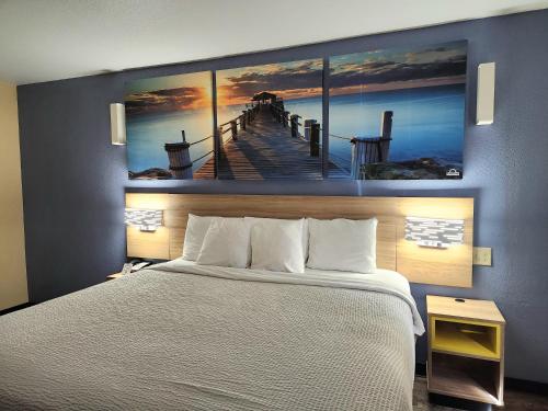 a bedroom with a bed and a painting of a pier at Days Inn by Wyndham New Orleans Pontchartrain in New Orleans