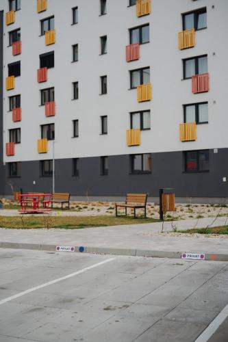 a large white building with benches in front of it at Bluetto in Trnava