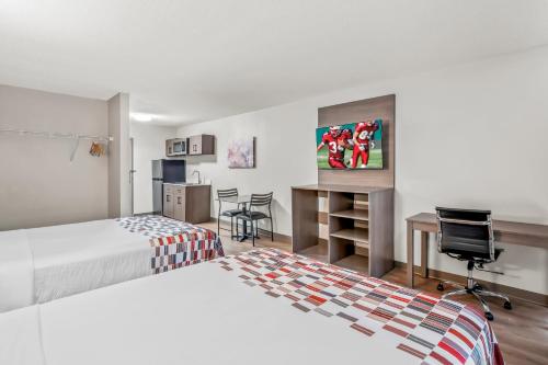 a hotel room with two beds and a desk at Red Roof Inn Southfield in Southfield