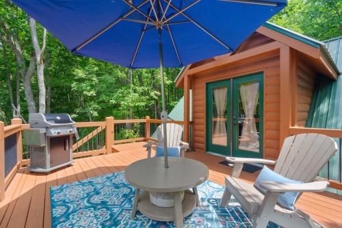 a patio with a table and chairs and an umbrella at Couples Carriage House Retreat-Wineries & Hiking in Dahlonega