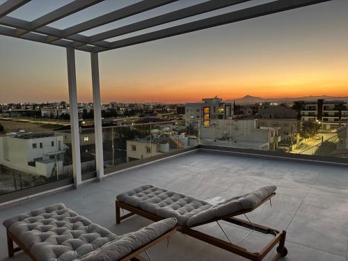 a view of a city from a balcony with a couch at Brandnew Rooftop Flat near Larnaca Mall in Larnaca