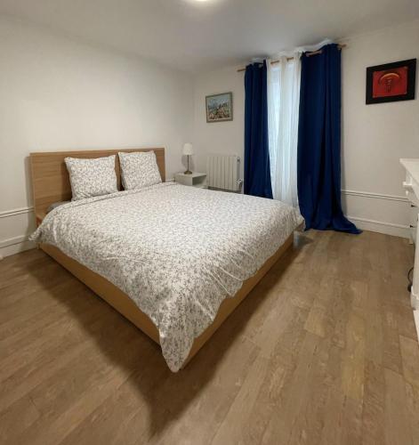- une chambre avec un grand lit et des rideaux bleus dans l'établissement Mon Amour Vavin, à Paris
