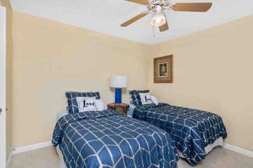 a bedroom with two beds and a ceiling fan at Aqua Breeze in Naples