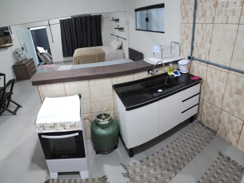 a small kitchen with a sink and a bedroom at Espaco confortavel, tudo novo in Rondonópolis