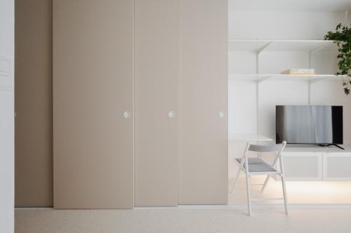 a white room with a chair and a tv at Toffino in Trnava