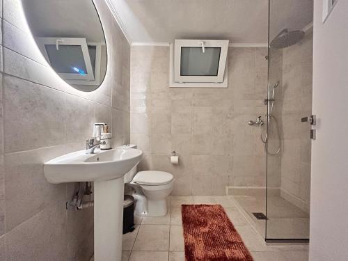 a bathroom with a sink and a toilet and a shower at Wake in the Lake III in Agios Nikolaos