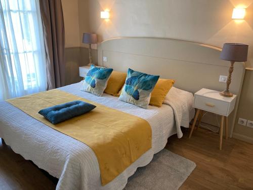 a bedroom with a large bed with blue pillows at Appartement T2 sur le Golf de Saint Endréol,spa,piscine in La Motte