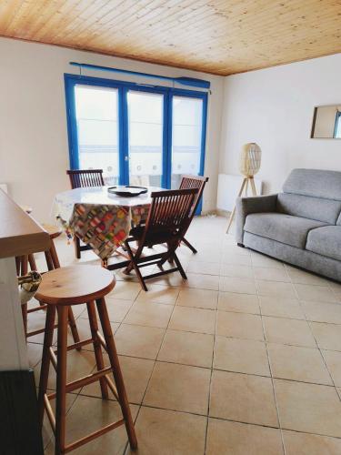 un salon avec une table, des chaises et un canapé dans l'établissement Maison souvenir, à Andernos-les-Bains