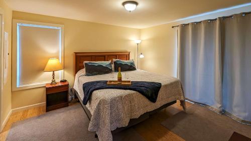 a bedroom with a bed and a lamp and a window at SQ Olympic-View-Cottage in Sequim