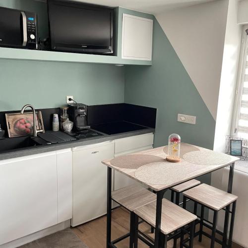 une petite cuisine avec une table et un micro-ondes dans l'établissement Sublime studio en face de la Moselle, à Chavelot