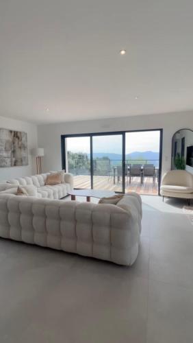 un salon blanc avec un canapé blanc et une table dans l'établissement Villa vue sur le golf 1, à Olmeto