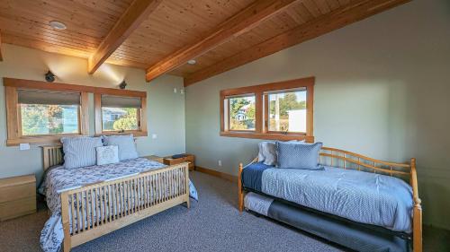 a bedroom with two beds and two windows at SQ Waters-Edge in Sequim