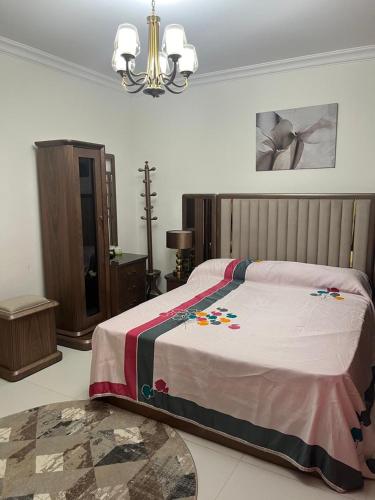 a bedroom with a bed and a chandelier at Chalet in marassi marina pool view exm80 in El Alamein