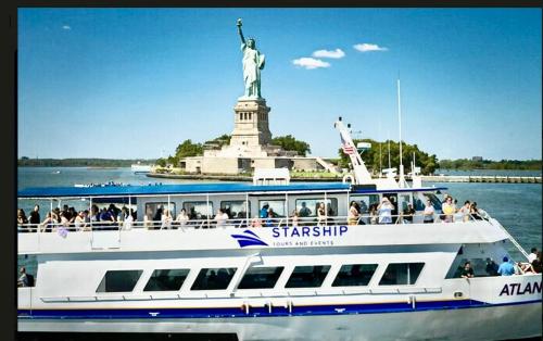 a boat in front of the statue of liberty at Apart Studio 12mint From New York City Times Square in West New York