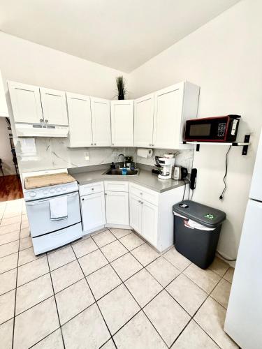 a small kitchen with white cabinets and a sink at Apart Studio 12mint From New York City Times Square in West New York