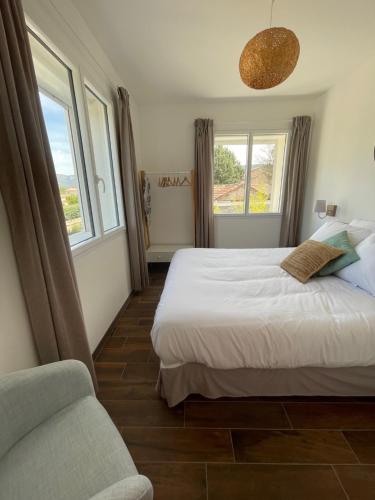 a bedroom with a bed and a couch and windows at Les Restanques in Trets