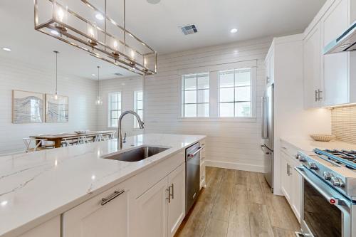 a kitchen with white cabinets and a sink at Sunrise Sunset Repeat in Port Aransas