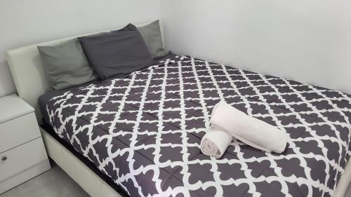 a black and white bed with two towels on it at Funston in Hollywood