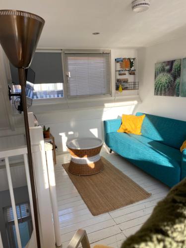 a living room with a blue couch and a table at Appartement 4 Seasons Katwijk aan Zee in Katwijk aan Zee