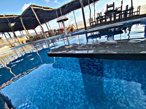 a pool of blue water with a table and chairs at Las delicias del paraiso in Armería