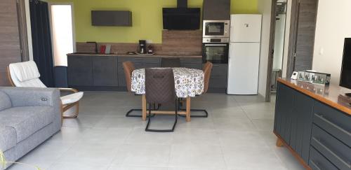 - une cuisine avec une table, des chaises et un canapé dans l'établissement Maison de vacances, à Pézenas