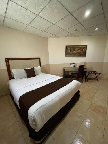 a bedroom with a large bed and a desk at El Regio in Monterrey