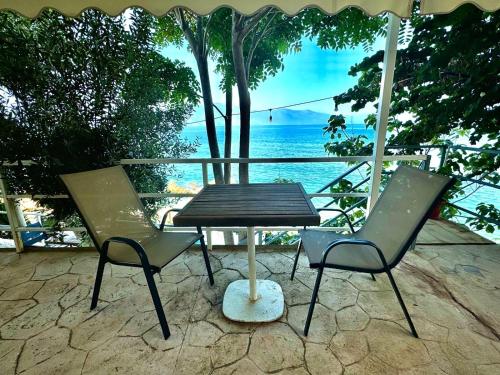 two chairs and a picnic table with a view of the ocean at Vila Rahmi & Veli Dervishaj in Vlorë