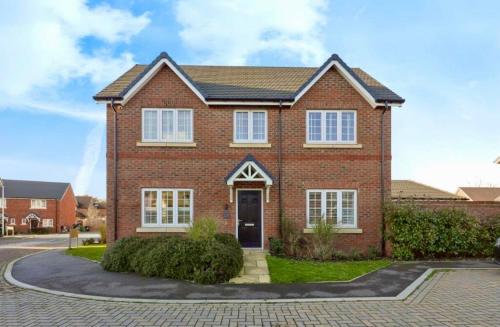 a red brick house with a driveway at Sleeps 8, off-road parking for 3 cars, pet friendly, welcome hamper in Tile Hill