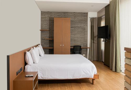 a hotel room with a bed and a tv at Hotel Viaggio Nueve Tres in Bogotá