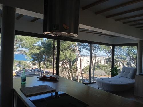 a kitchen with a counter and a large window at Villa vu mer et étang de thau in Sète