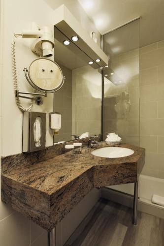 a bathroom with a sink and a large mirror at SOALTEE Hotel by Trip Inn Frankfurt Messe Tagungshotel in Frankfurt/Main