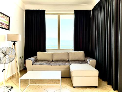 a living room with a couch and a large window at Vila Rahmi & Veli Dervishaj in Vlorë