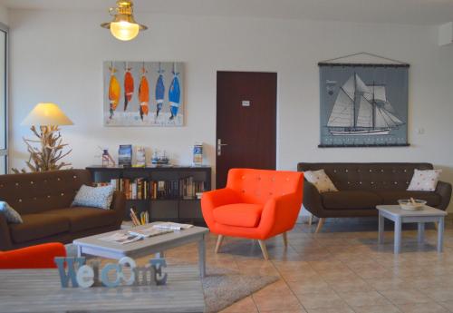 a living room with couches and chairs and a table at Hotel L'Oceane in La Cotinière