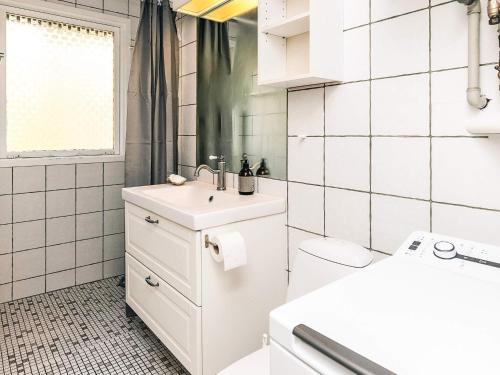 a white bathroom with a sink and a toilet at Secluded Beach Retreat - By Traum Ferienwohnungen in Lihme