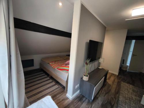 a small bedroom with a bed and a television at Ferienwohnung im Bergischen Land in Much