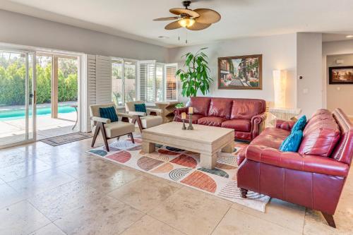 a living room with a red leather couch and a table at Gateway Grand Oasis Palm Springs Gem with Pool! in Palm Springs