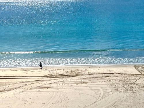 a person walking on the beach near the ocean at Martina & Playa in Sanxenxo
