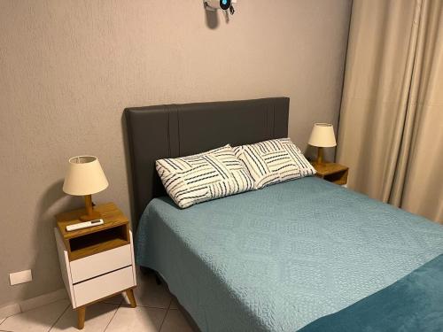 a bedroom with a bed and two night stands with lamps at A melhor vista de São Vicente in São Vicente