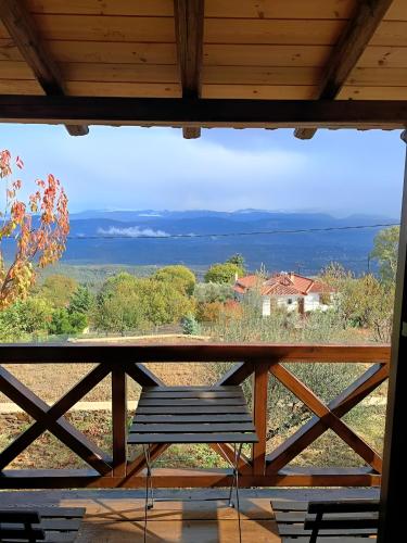 a bench sitting on a porch with a view of the ocean at Luxury House In The Hills in Sparti